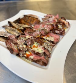 New York Strip and portabella mushrooms charbroiled by Chef Will O'Kelley on Vulcan VACB25 cut and on a plate.