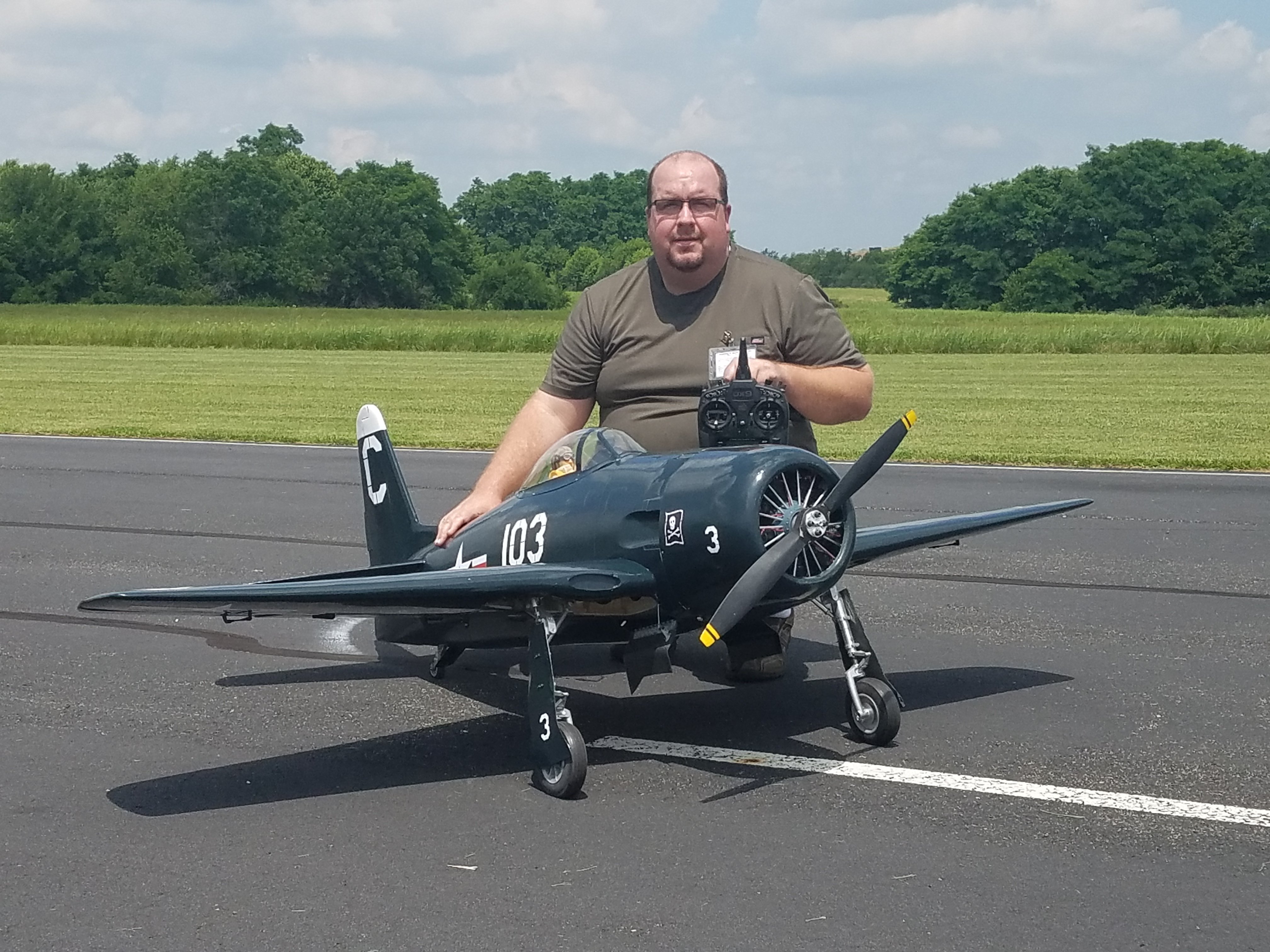 man crouching with a model airplane