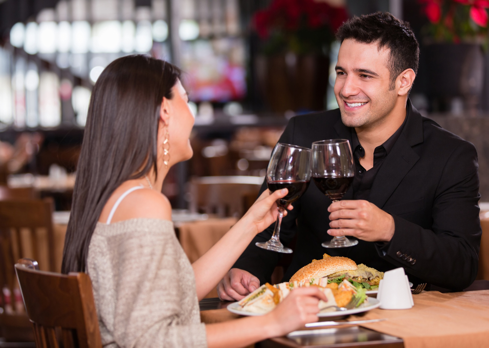Couple having dinner at a restaurant and making a toast Couple having dinner at a restaurant and making a toast